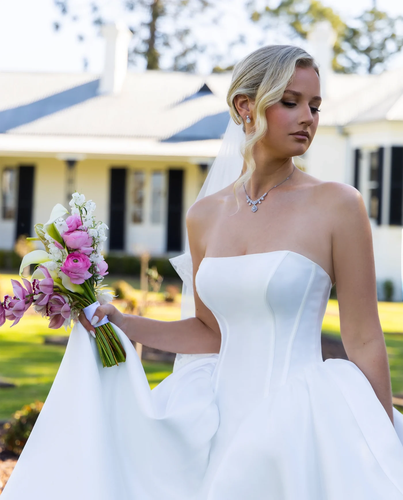 The bride holding a pink and white bouquet in the garden.